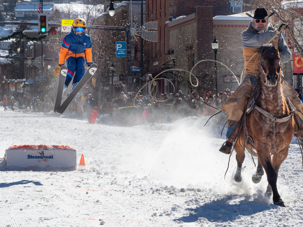 kid jumping in ski jacket and pants at Steamboat Winter Carnival skijoring