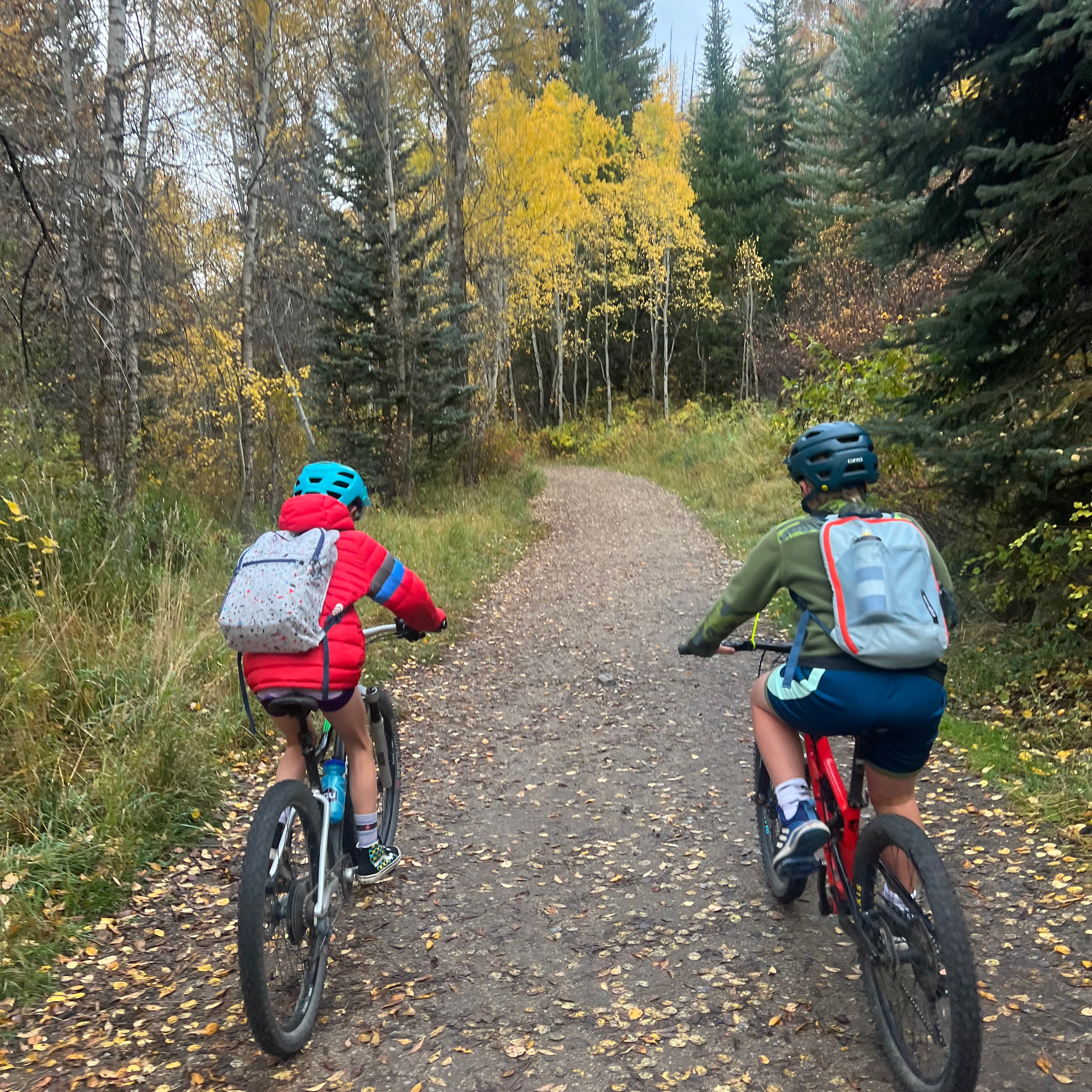 Kids ride bikes to school in the fall leaves of Steamboat