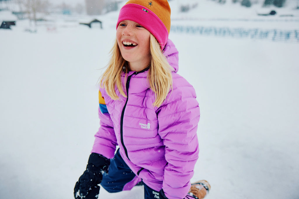 kid smiling in town hall down town puffy in snow
