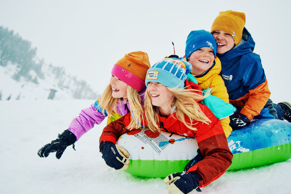 Kids sledding blissfully in Town Hall outerwear