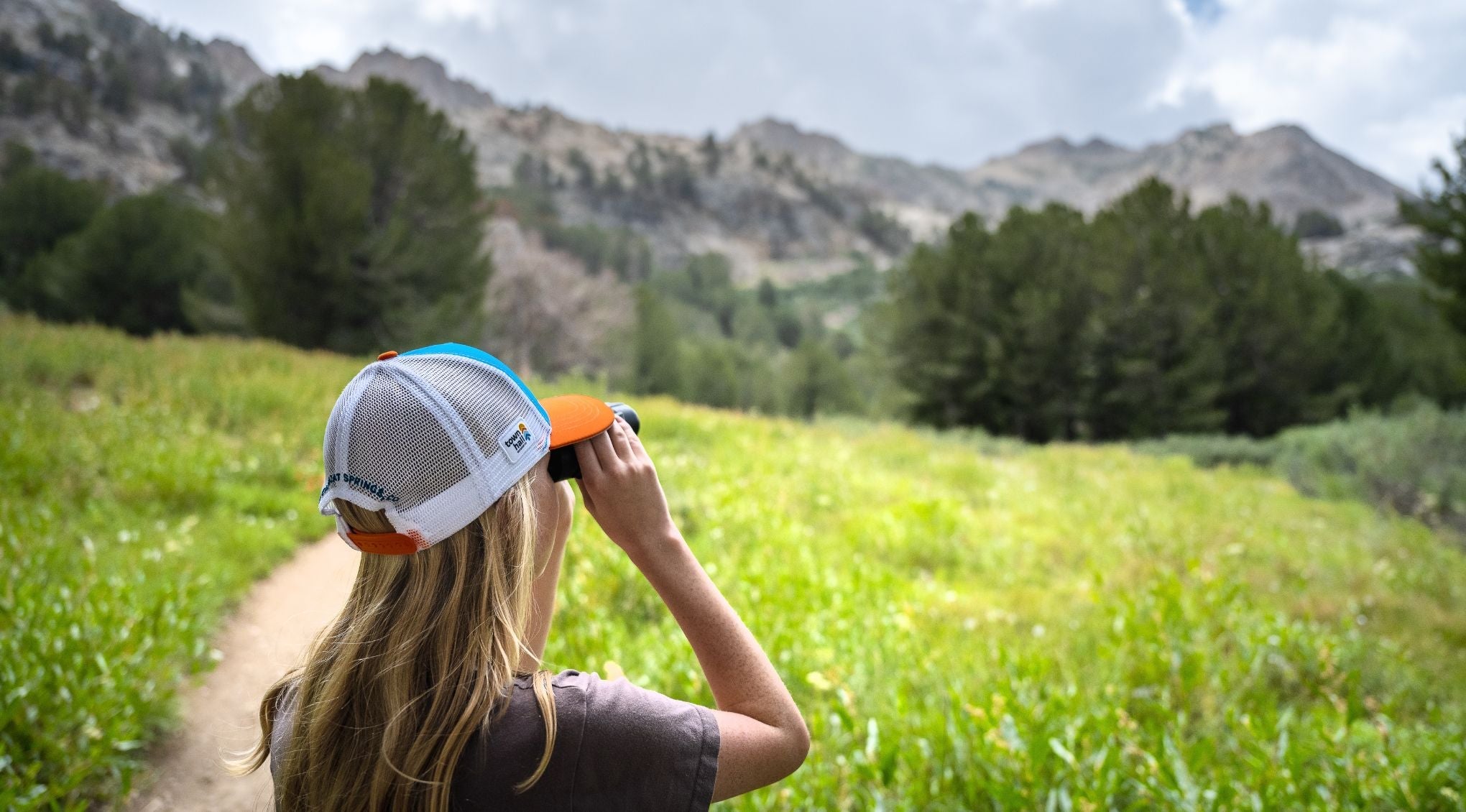 Warm Weather Gear - girl looking at mountains wearing a hat