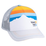 Town Hall adult Trucker Hat with white mountain graphic, yellow and orange sky stripes, blue accents and gray mesh.