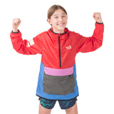 Girl exploring outdoors in the bright Goji Berry About Town Anorak, showcasing the Town Hall logo, protective hood, and weather-resistant design for year-round adventures.