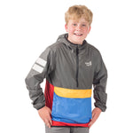 Boy wearing the award-winning About Town Anorak in Dark Shadow color, featuring the Town Hall logo, wind-resistant hood, and kangaroo pocket perfect for unpredictable weather adventures.