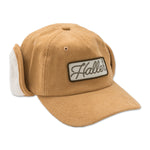 Haller Ear Flap Hat shown from the front with flaps up, featuring the Haller logo with classic Fudd-style winter warmth for outdoor adventures. 