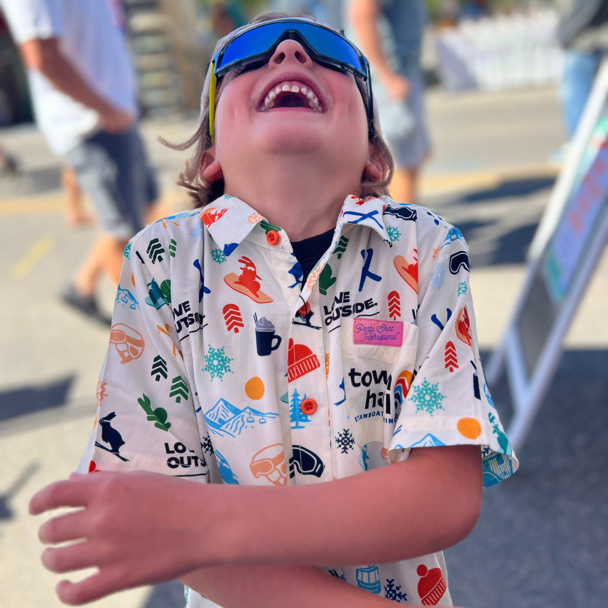 Child wearing a colorful shirt with various patterns outdoors