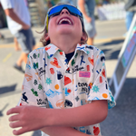 Child wearing a colorful shirt with various patterns outdoors