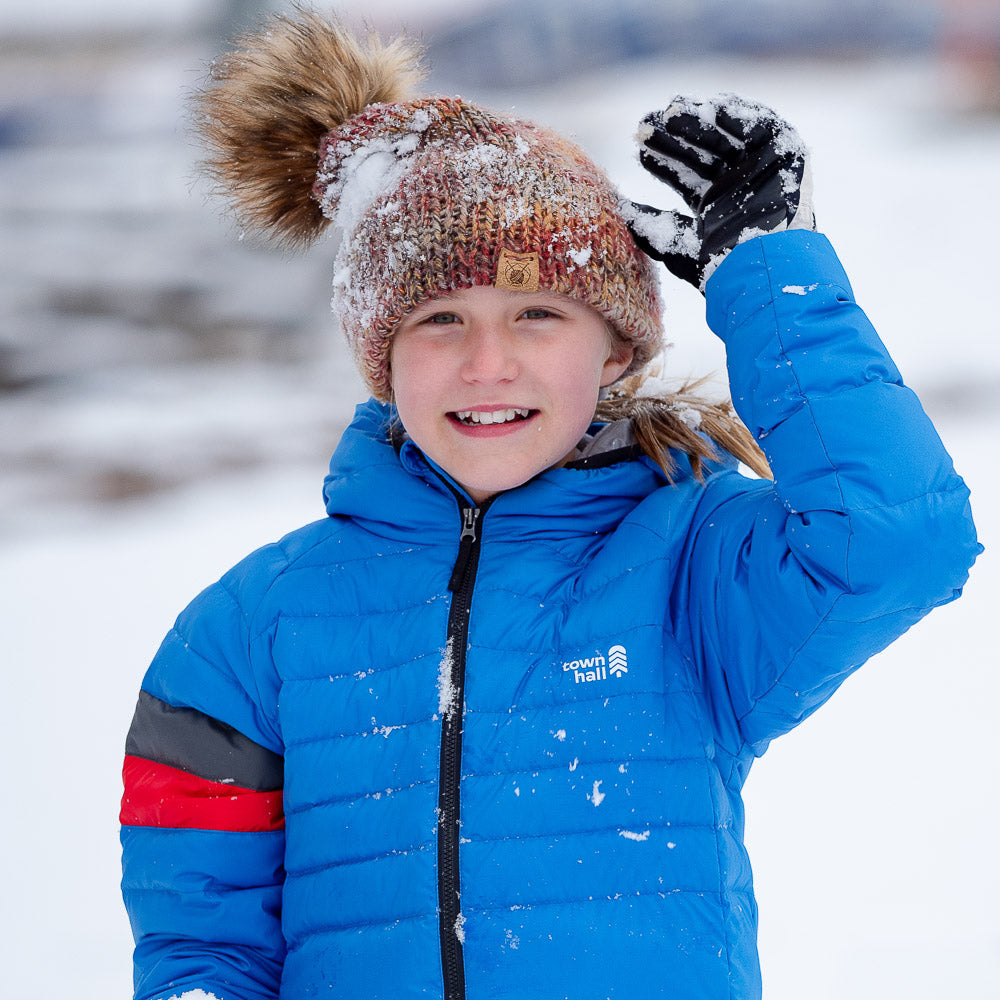 Kid playing in snow in recycled down puffy jacket