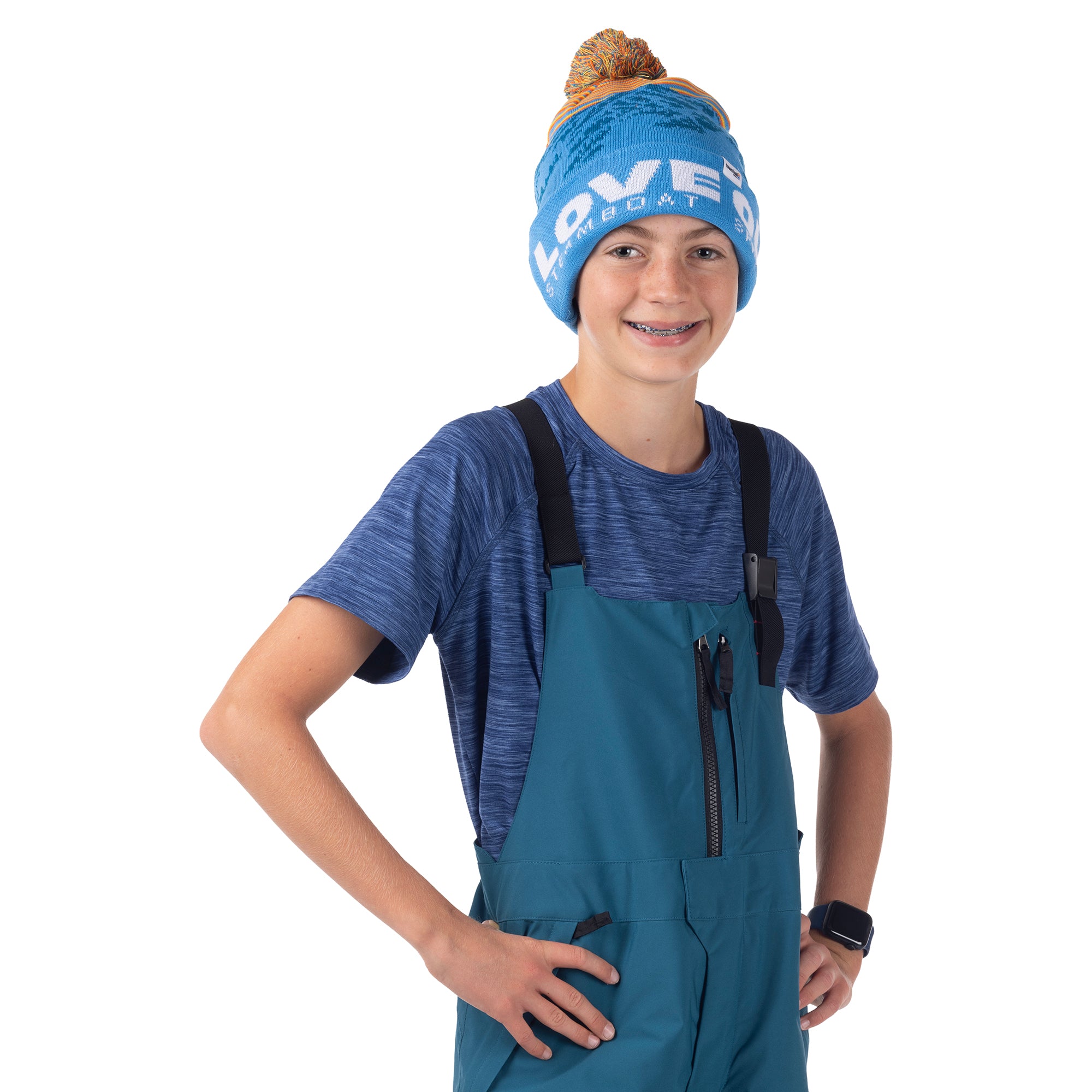 Child modeling a Blue Coral Mountain Town kids snow bib, showing black shoulder straps and zippered chest pocket