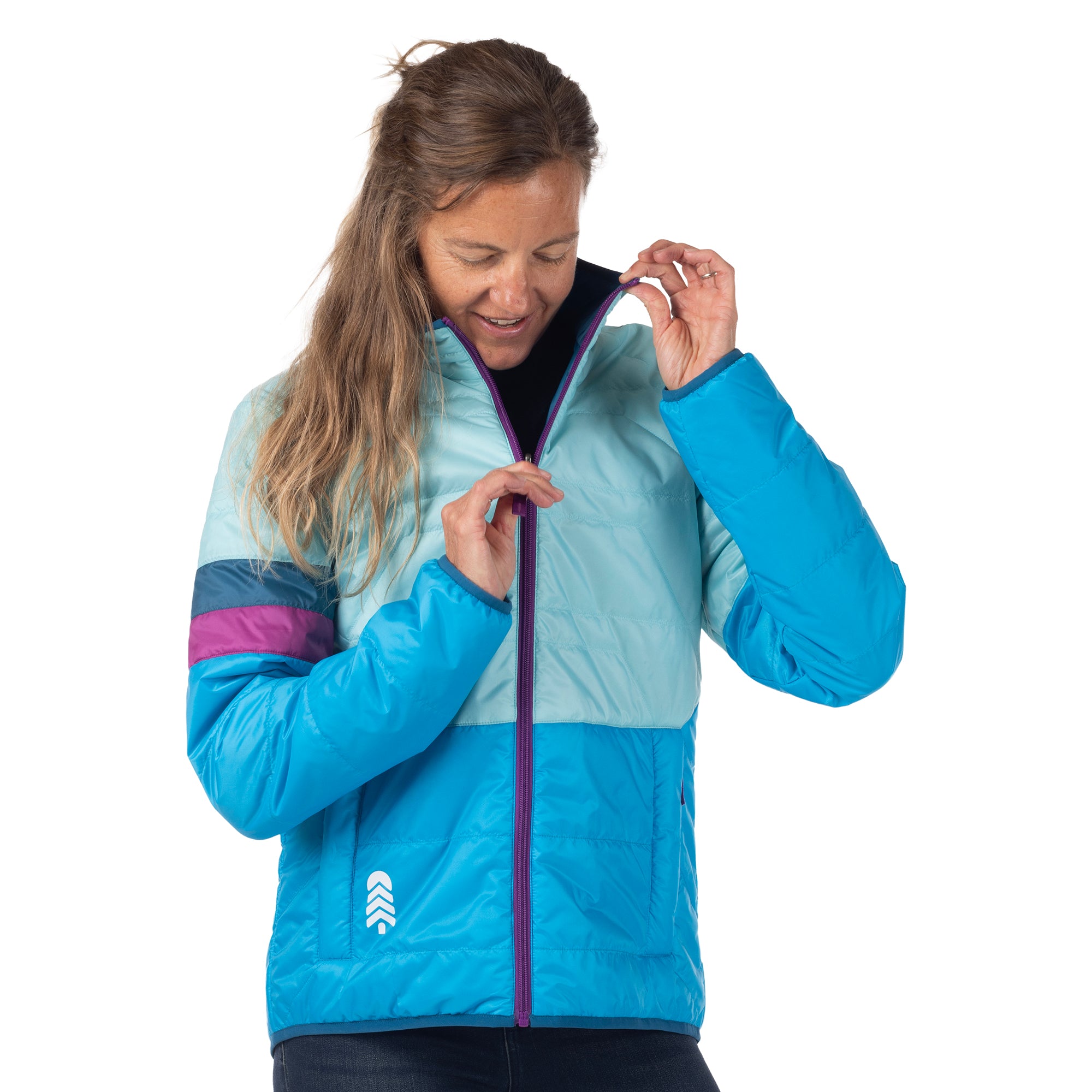 Woman adjusting the purple zipper on an aqua and blue Town Hall OuttaTown Reversible Jacket.