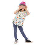 Child wearing Town Hall Kids Cabana Shirt in Vanilla with colorful ski-town print and a pink Love Outside cap.