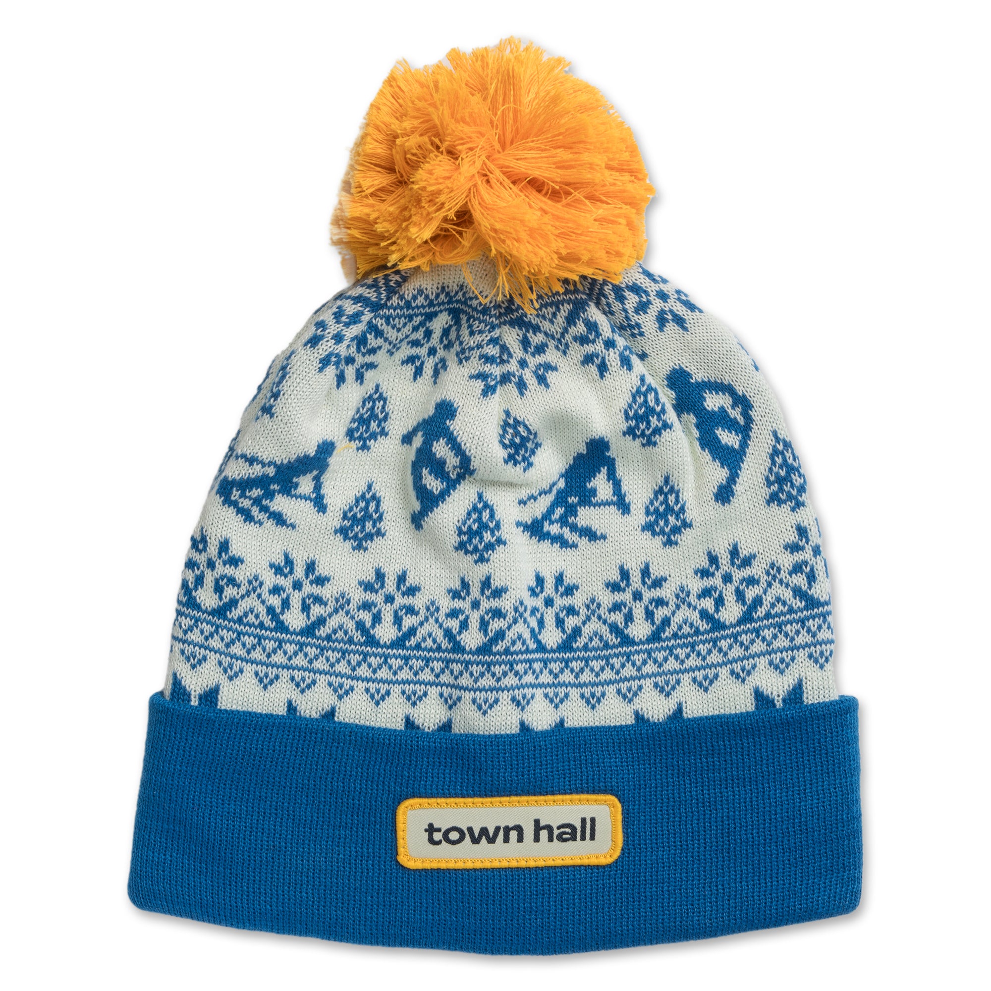Blue kids beanie with playful snowy mountain scene and skier pattern, featuring the Town Hall logo on the folded cuff and topped with a cozy pom.