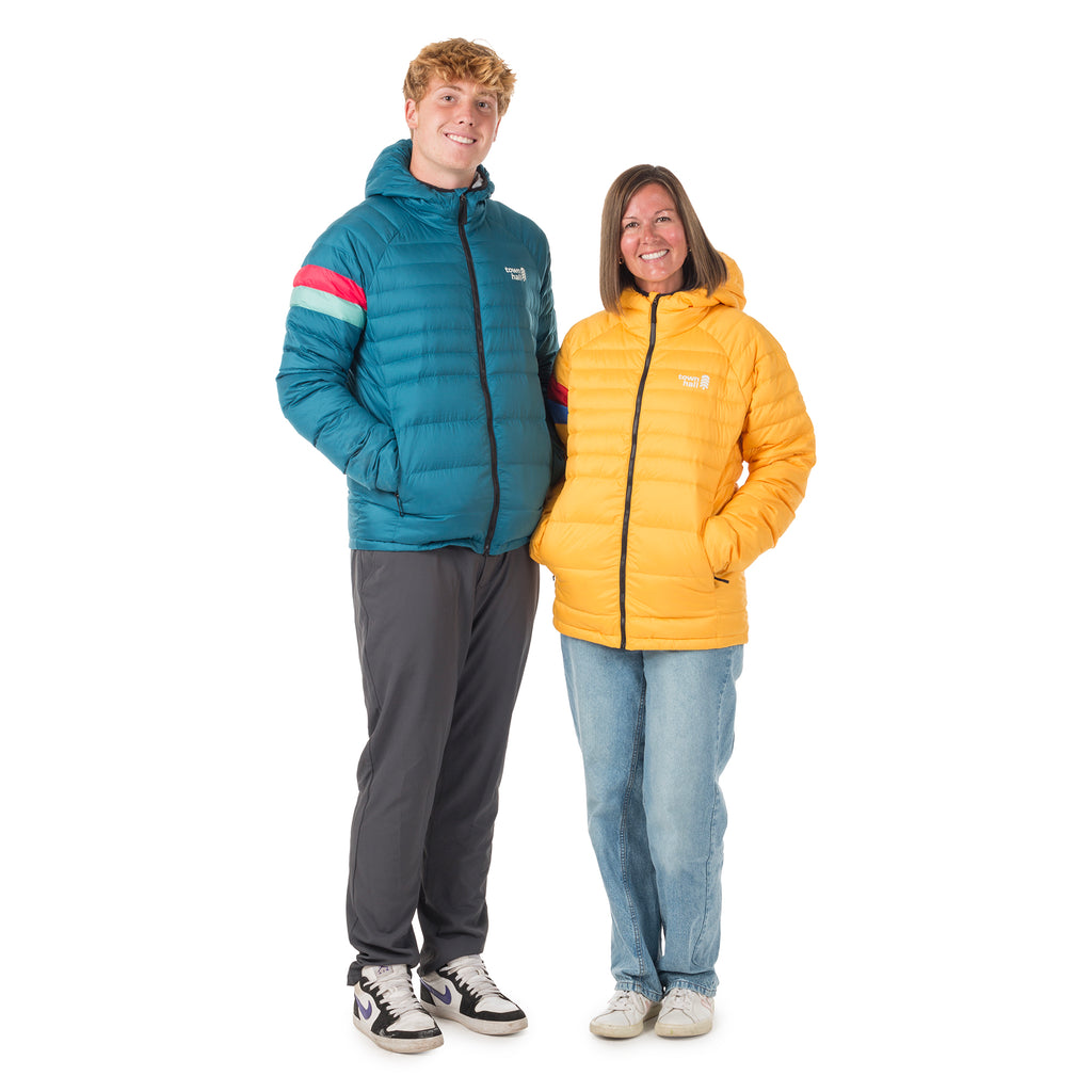 Adult woman and young adult man standing side by side in matching Adult Down Town Puffy jackets by Town Hall, demonstrating the gender-neutral fit and versatile outdoor style.