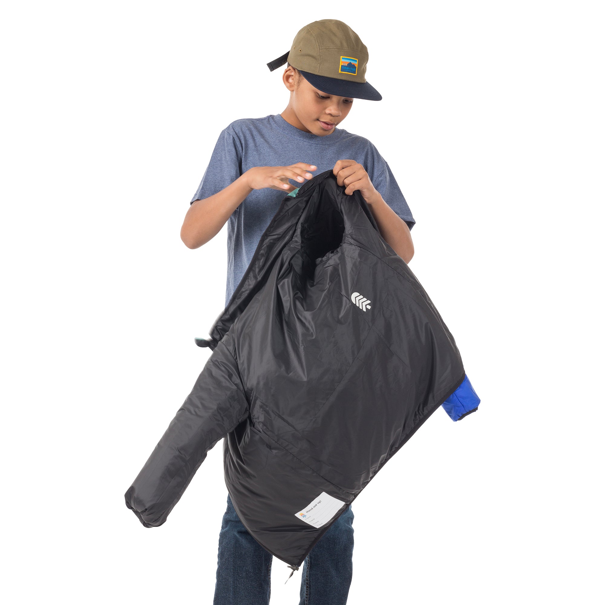 Teen boy flipping the Skip Town insulated jacket inside out, showing how easily kids can change looks when adventure takes them from cool mornings to warm afternoons.