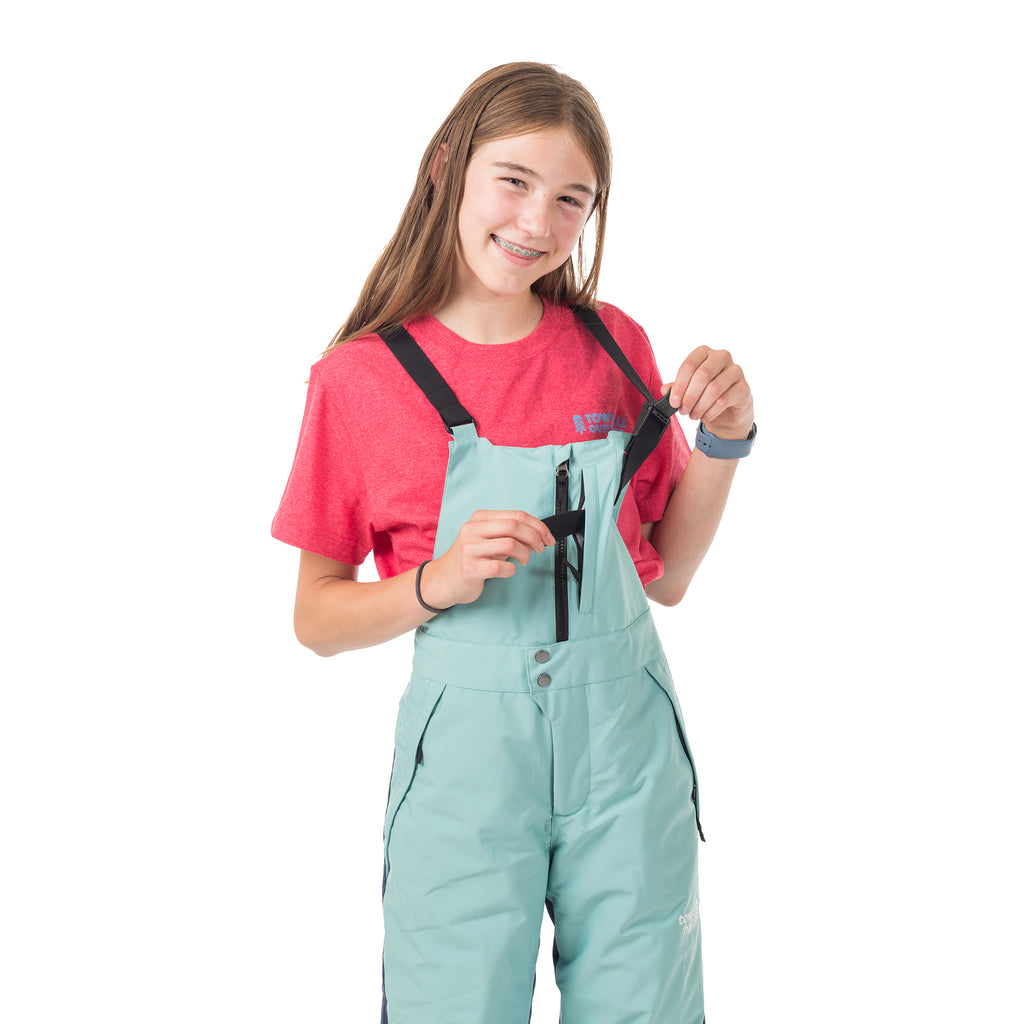 Child demonstrating the shoulder strap adjustments on Town Hall's Canton Winter Bib, showcasing the user-friendly design that kids can manage themselves.