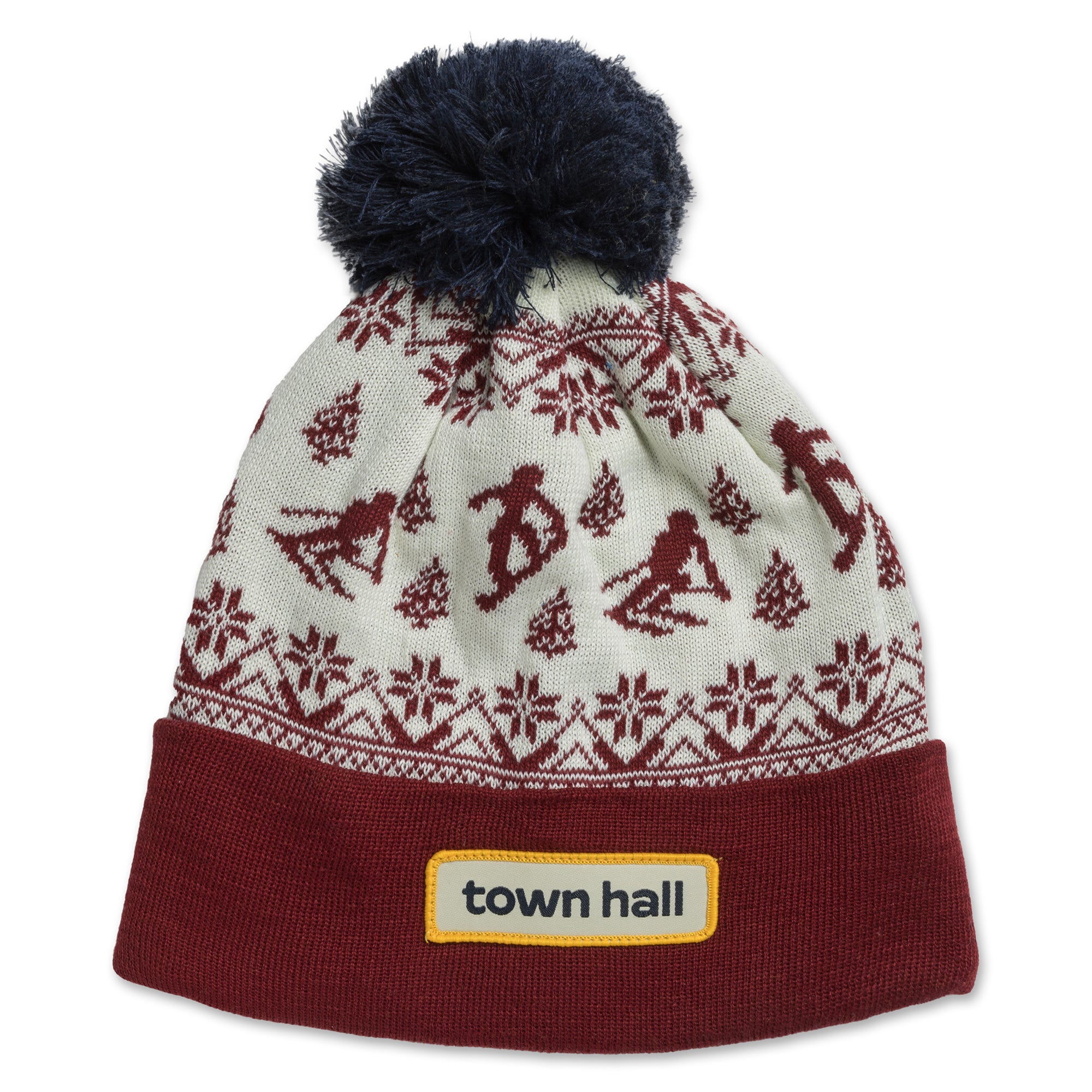 Magenta Thunderhead adult beanie featuring a vintage-inspired pattern of snow and skiers, with the Town Hall logo on the folded cuff front, topped with a playful pom.