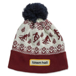 Magenta Thunderhead adult beanie featuring a vintage-inspired pattern of snow and skiers, with the Town Hall logo on the folded cuff front, topped with a playful pom.