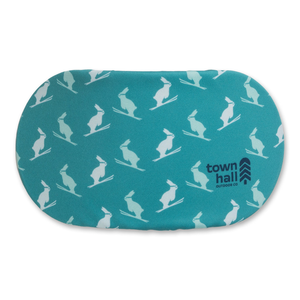 Teal Ski and Ride Bunny goggle cover shown ready to protect eyewear during lift rides and lodge breaks while doubling as a lens wipe. 