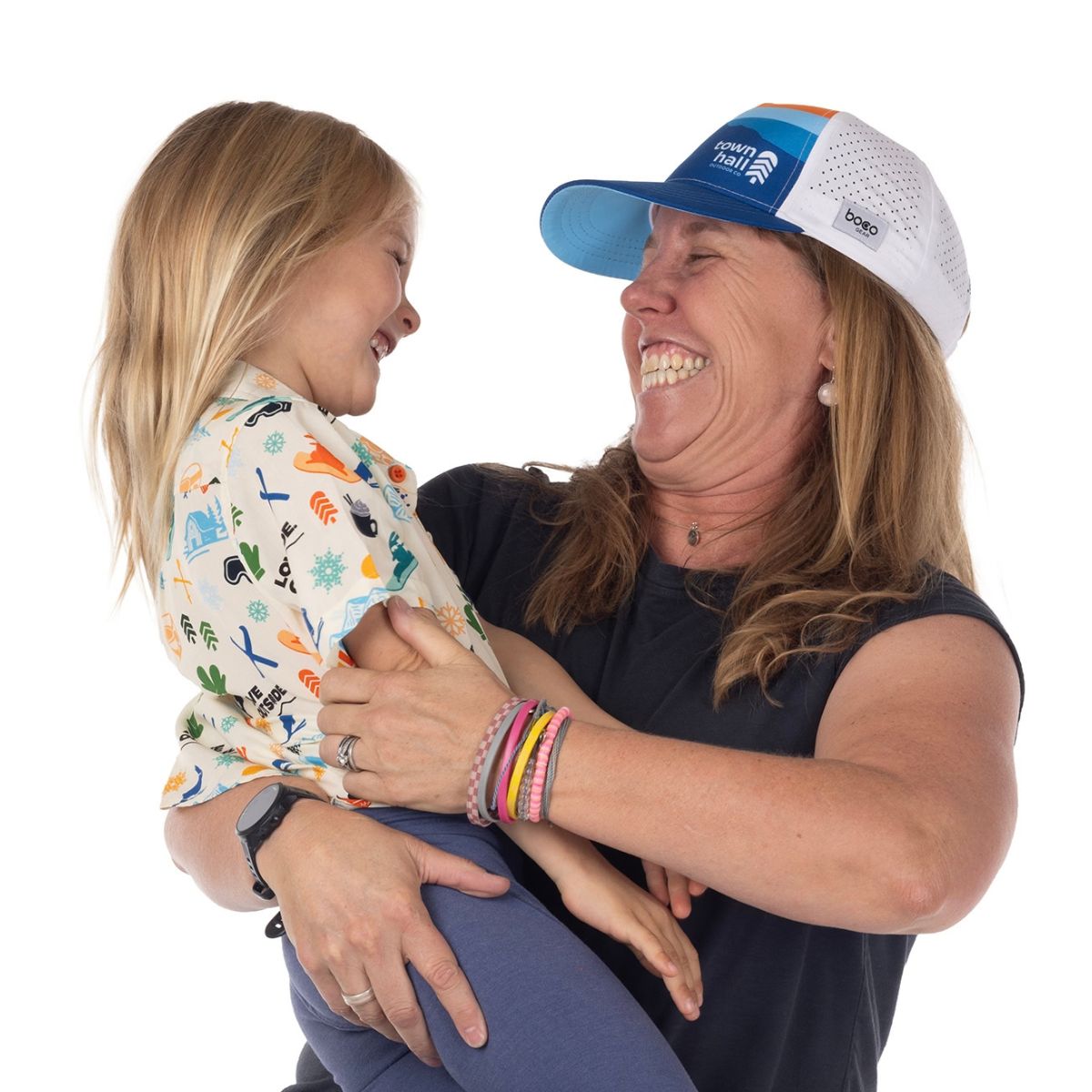 Woman and little girl laughing while mom wears a running trucker hat with performance mesh