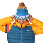 Teenage boy putting on a colorful knit beanie with mountains and stripes on it, that says Love Outside, Steamboat Springs, CO