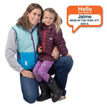 mom and daughter kneeling and smiling, wearing puffy vest and coat with lots of colors.