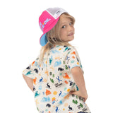 Child wearing a pink Kids Trucker Hat backward, showing its white mesh panels and blue underside of the brim.