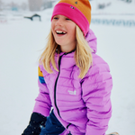 Person wearing a purple jacket and colorful beanie in a snowy setting
