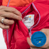 Red puffer jacket with 'town hall' and 'title nine' labels, featuring a 'Partnership Magic' badge.