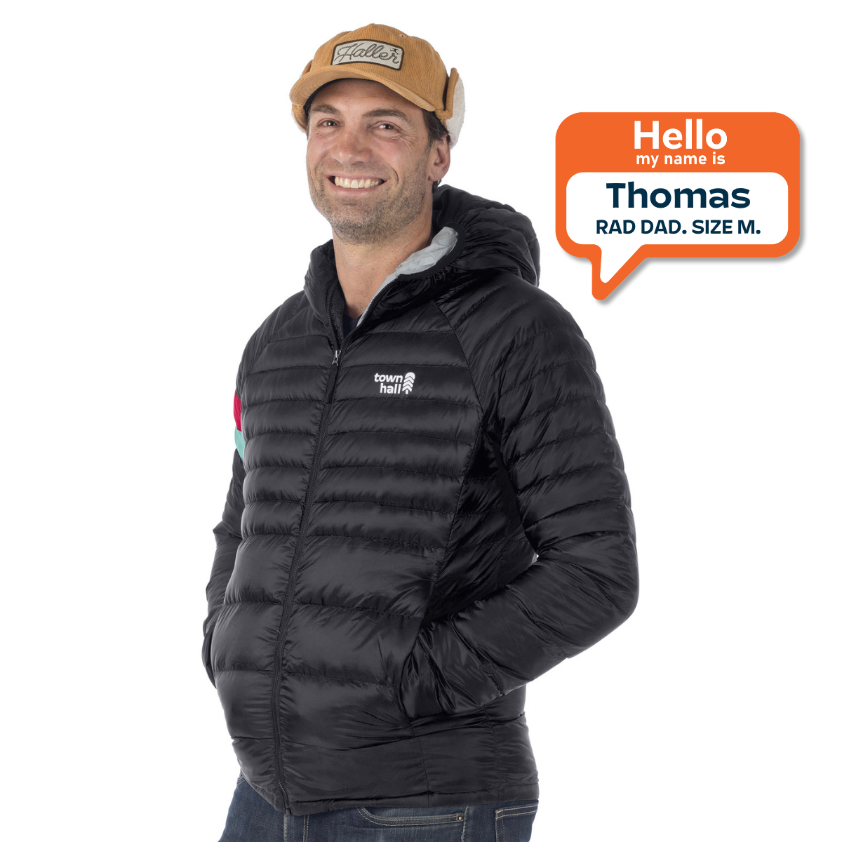 A man wearing a black hooded puffer jacket and a tan baseball cap, with an orange speech bubble graphic on the right that reads 'Hello my name is Thomas RAD DAD, SIZE M.'.