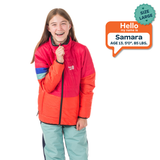 Child wearing a red and orange jacket with a 'Hello my name is Samara' label.