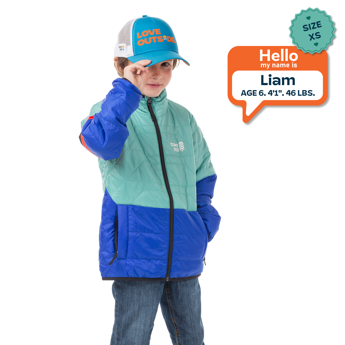 Child wearing a blue and green jacket with a cap, standing against a white background.