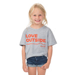 Young girl ready for outdoor adventures in our Heather Gray Kids Love Outside Tee with Town Hall logo and playful front message.