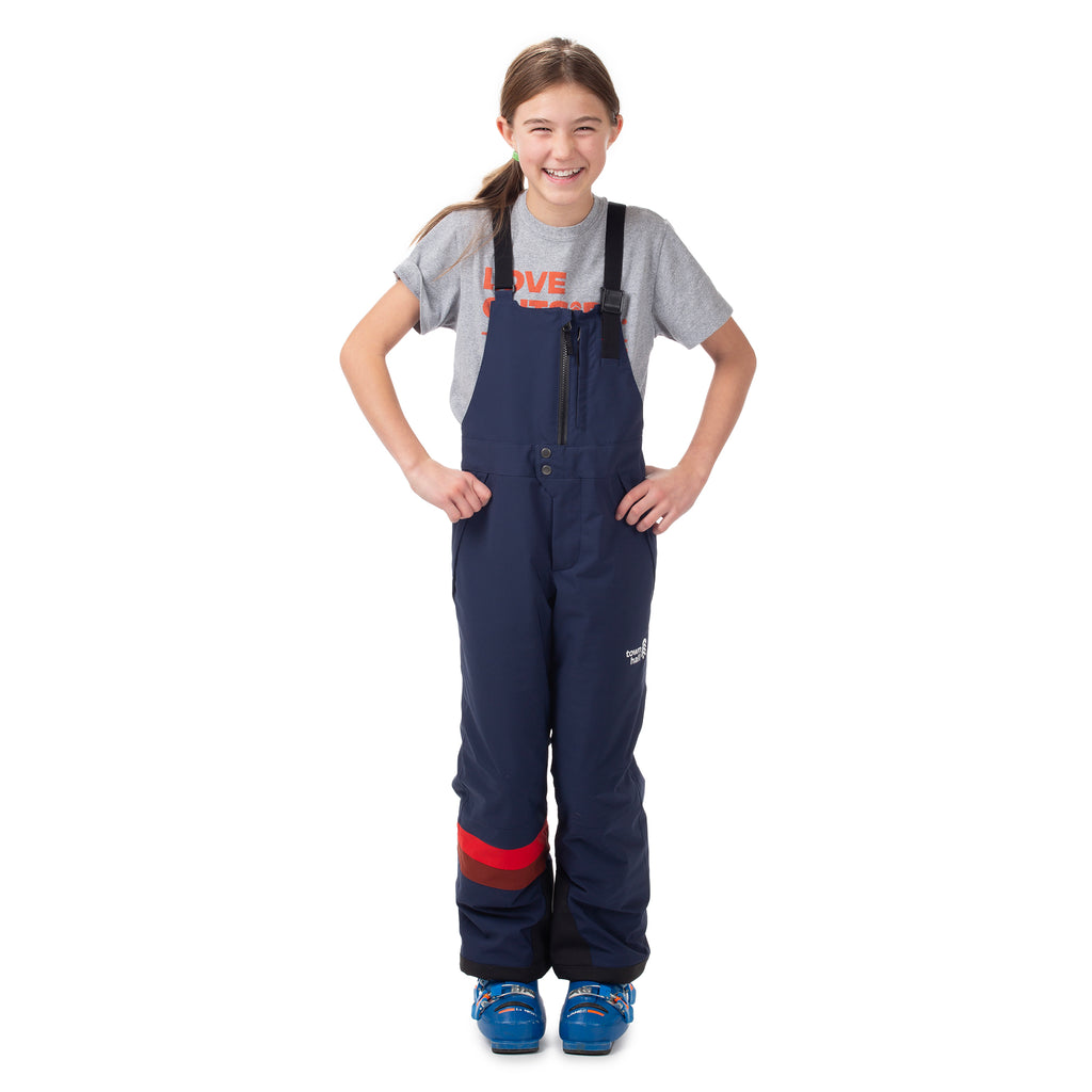 Child modeling Town Hall's Mountain Town Winter Bib in Black Iris, perfect for keeping young skiers and sledders warm and dry during all-day snow adventures